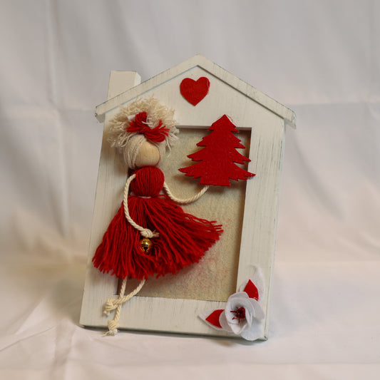 Cornica con bambolina rossa